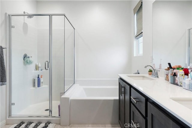 full bath featuring double vanity, a sink, a bath, and a stall shower