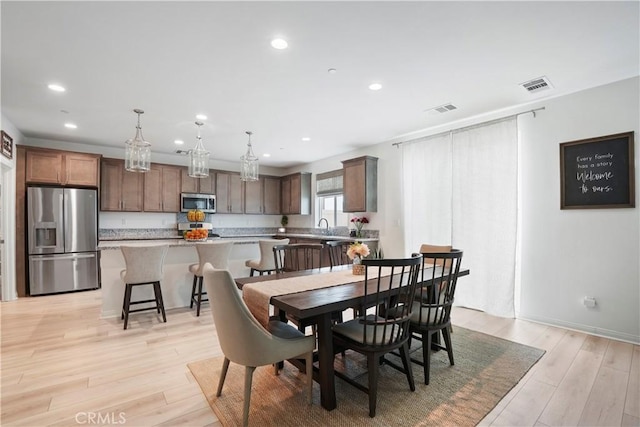 dining space with recessed lighting, baseboards, light wood-type flooring, and visible vents