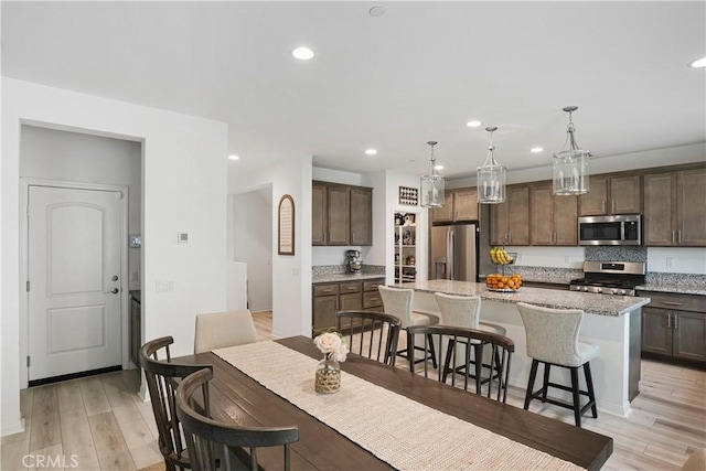 dining room featuring recessed lighting, baseboards, and light wood-type flooring