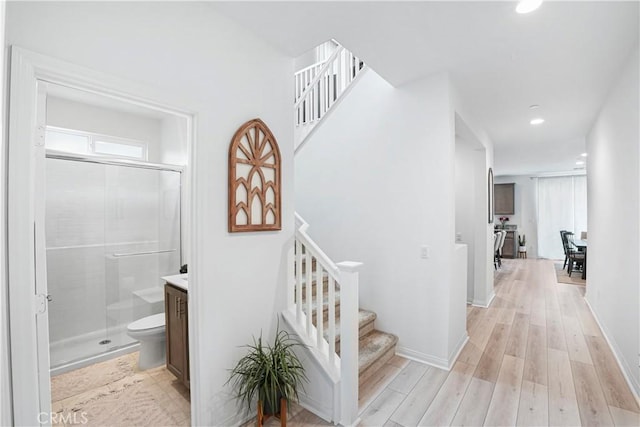 corridor with light wood-style floors, recessed lighting, stairs, and a healthy amount of sunlight