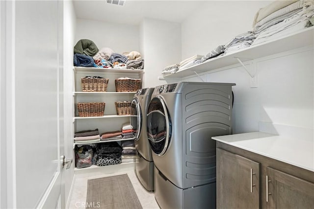 washroom with visible vents, laundry area, and washer and clothes dryer