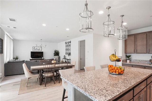 kitchen featuring a chandelier, visible vents, light wood finished floors, open floor plan, and recessed lighting