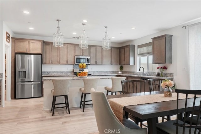 kitchen featuring a center island, stainless steel appliances, recessed lighting, and decorative light fixtures