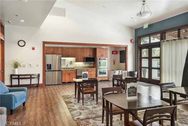 dining space featuring a high ceiling, wood-type flooring, recessed lighting, and visible vents