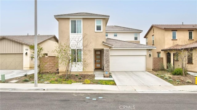 traditional-style house with fence, an attached garage, concrete driveway, and stucco siding