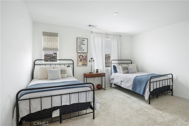 carpeted bedroom featuring baseboards, visible vents, and multiple windows