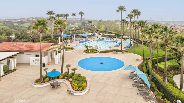 community pool with a patio area and fence