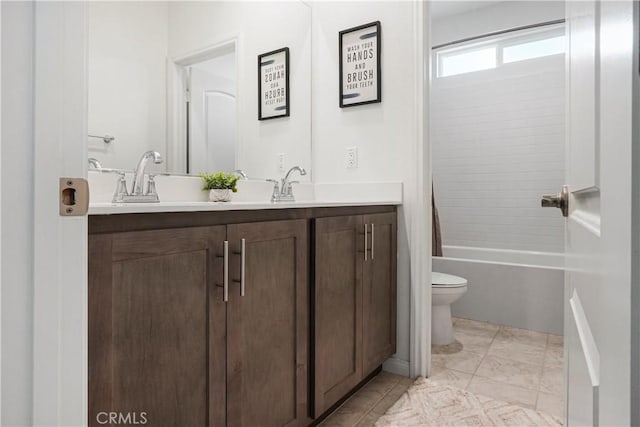 full bathroom featuring double vanity, a sink, shower / bath combo, and toilet