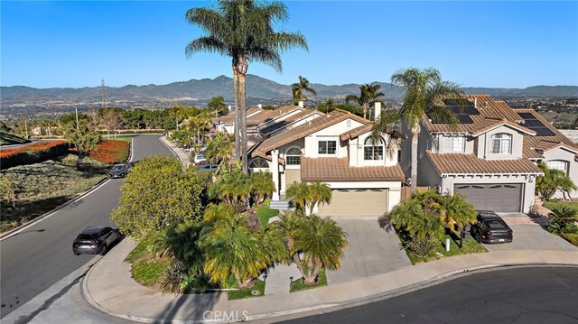 view of front of home featuring a tile roof, a mountain view, and driveway