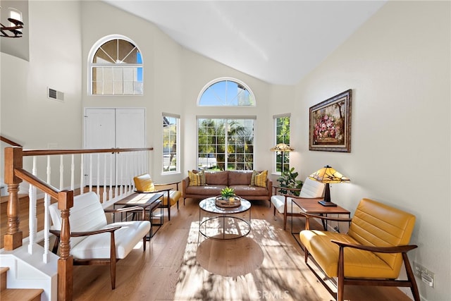 sitting room featuring hardwood / wood-style floors, visible vents, and high vaulted ceiling