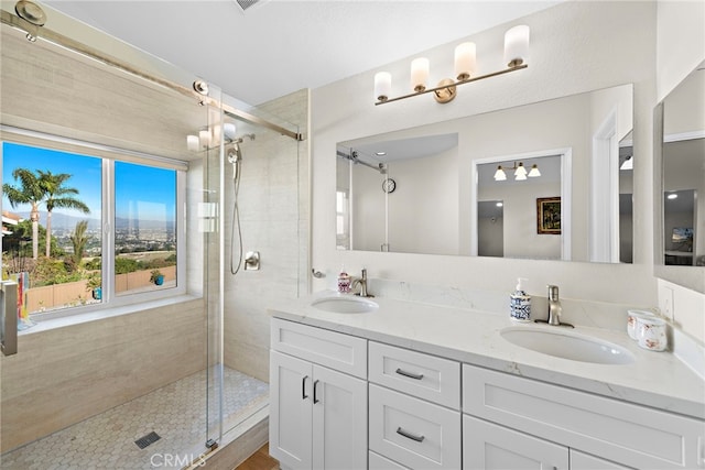 full bathroom with a shower stall, a sink, and double vanity