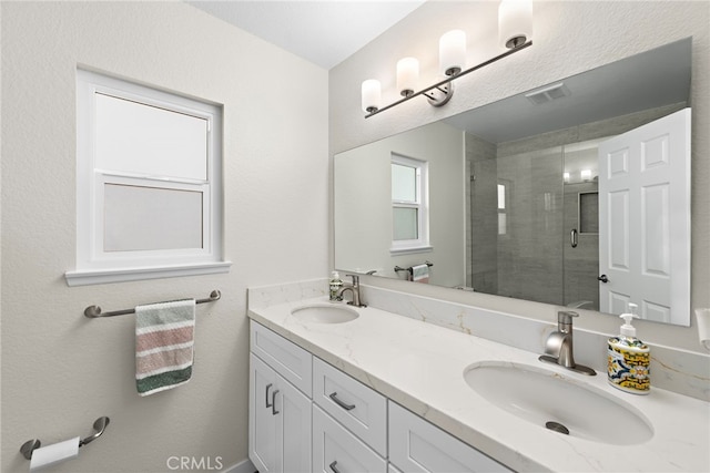 bathroom featuring a shower stall, a sink, visible vents, and double vanity