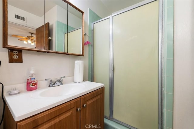 full bathroom with a ceiling fan, visible vents, vanity, and a shower with door
