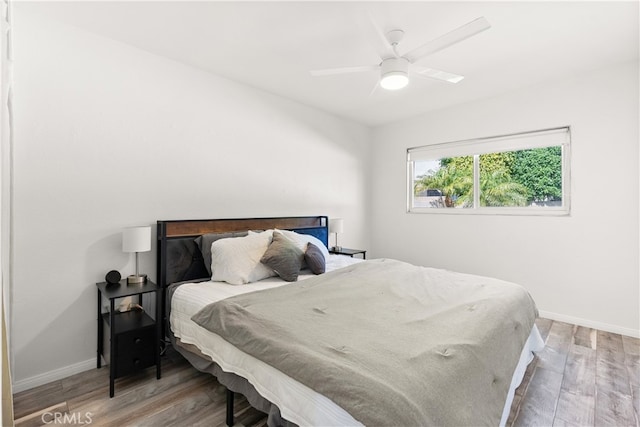 bedroom featuring ceiling fan, baseboards, and light wood-type flooring