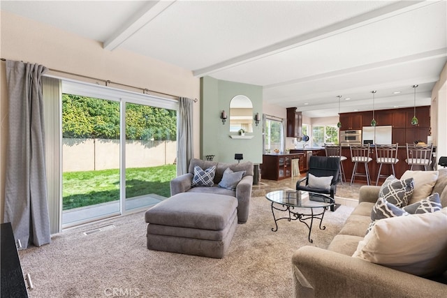 living area with beamed ceiling, visible vents, light carpet, and recessed lighting