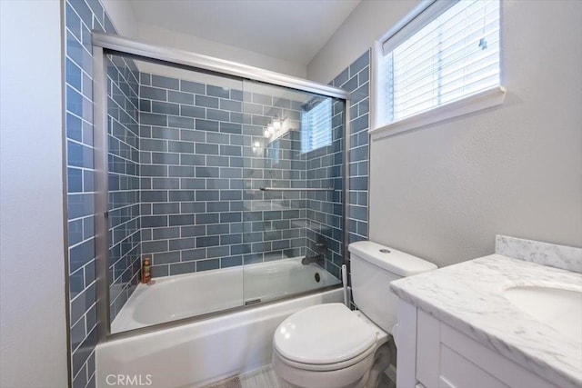 full bath with combined bath / shower with glass door, vanity, and toilet