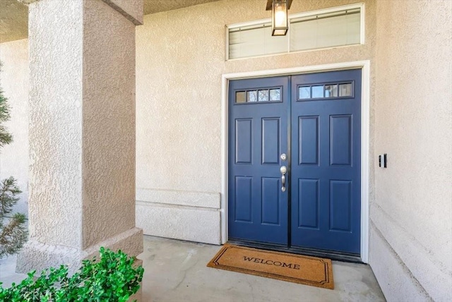 doorway to property featuring stucco siding