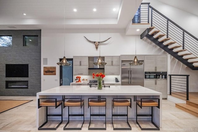 132628 Rainbow Ridge Ln, Encinitas, CA 92024 - kitchen with stainless steel appliances, modern cabinets, light countertops, a breakfast bar, and a large island
