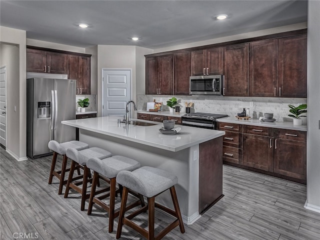35368 Garcia St, Beaumont, CA 92223 - kitchen featuring a breakfast bar area, light wood-style flooring, stainless steel appliances, and a sink