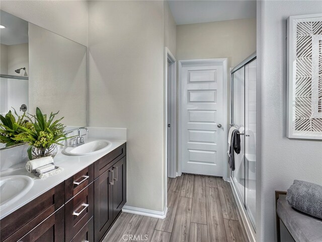 35368 Garcia St, Beaumont, CA 92223 - bathroom with baseboards, wood finished floors, a sink, and a shower stall