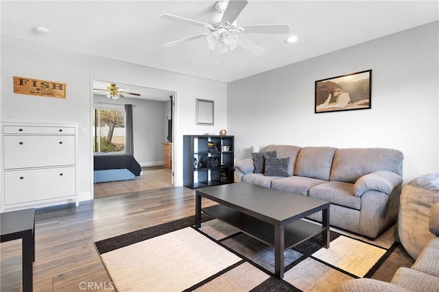 living area featuring baseboards, a ceiling fan, wood finished floors, and recessed lighting