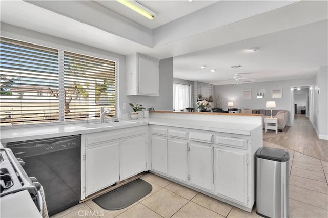 kitchen featuring a peninsula, light tile patterned flooring, light countertops, white cabinetry, and a sink
