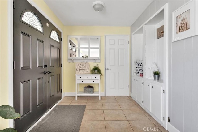 foyer featuring baseboards and light tile patterned flooring