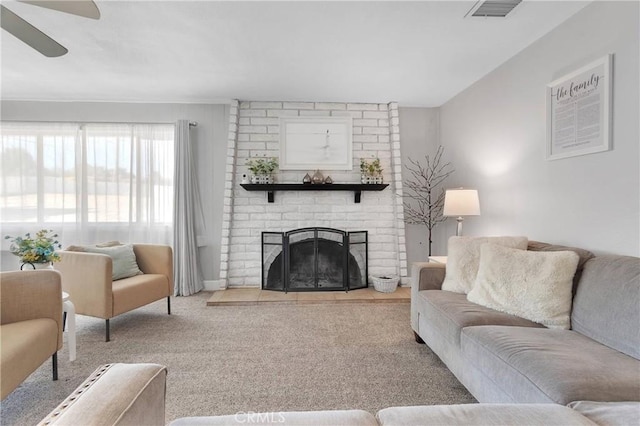carpeted living room with visible vents, a ceiling fan, and a fireplace