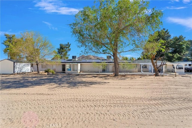 ranch-style home with roof mounted solar panels