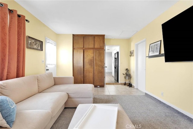 living room with light tile patterned flooring, baseboards, and light colored carpet