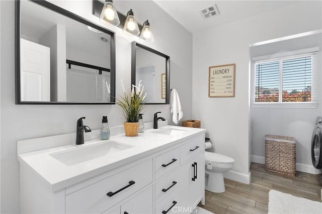 full bath featuring visible vents, a sink, wood finished floors, and toilet