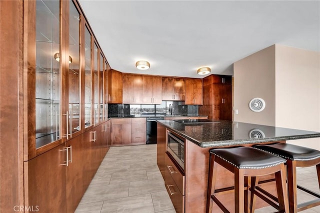 kitchen with tasteful backsplash, a kitchen breakfast bar, brown cabinets, stainless steel microwave, and dishwashing machine
