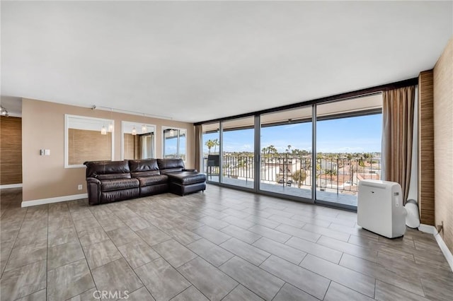 living area with expansive windows, a healthy amount of sunlight, and baseboards