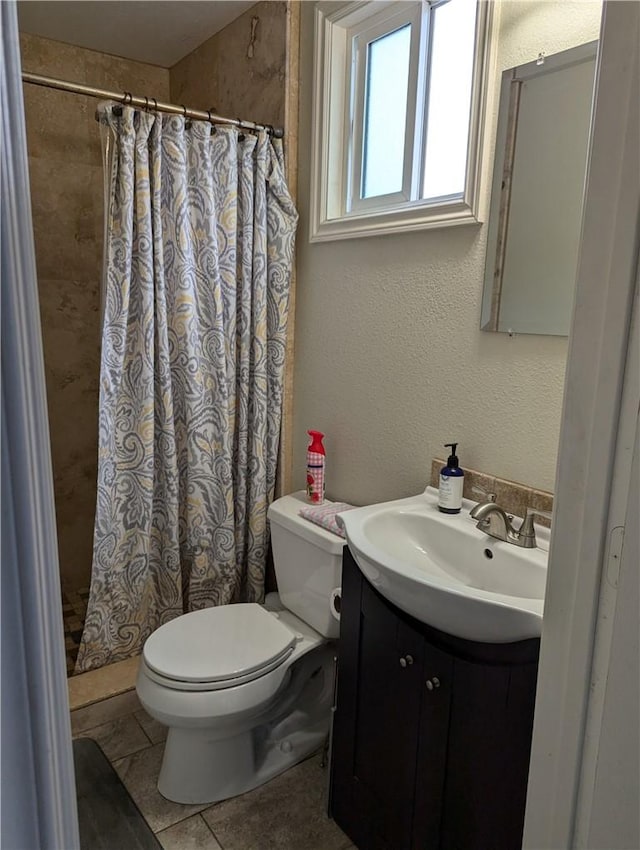 full bath featuring a shower with shower curtain, toilet, vanity, and tile patterned floors