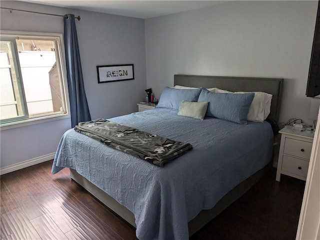 bedroom featuring baseboards and dark wood finished floors