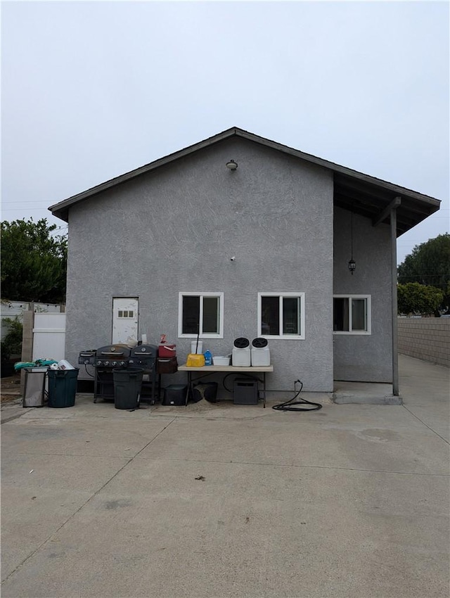 back of house with a patio area, stucco siding, and fence