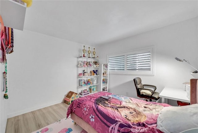 bedroom featuring baseboards and wood finished floors