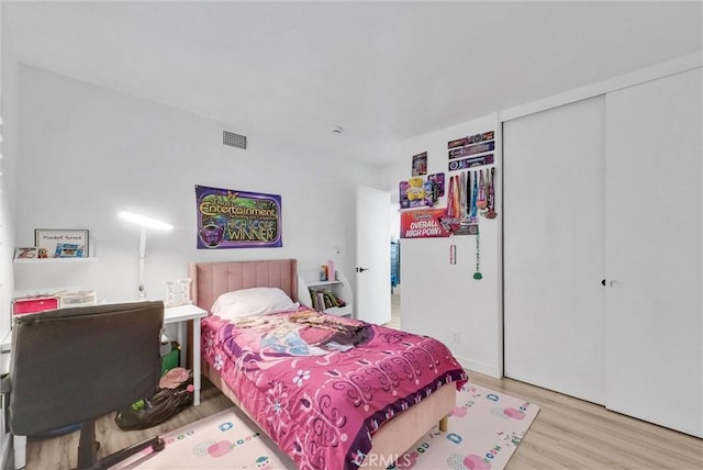 bedroom featuring a closet, wood finished floors, and visible vents