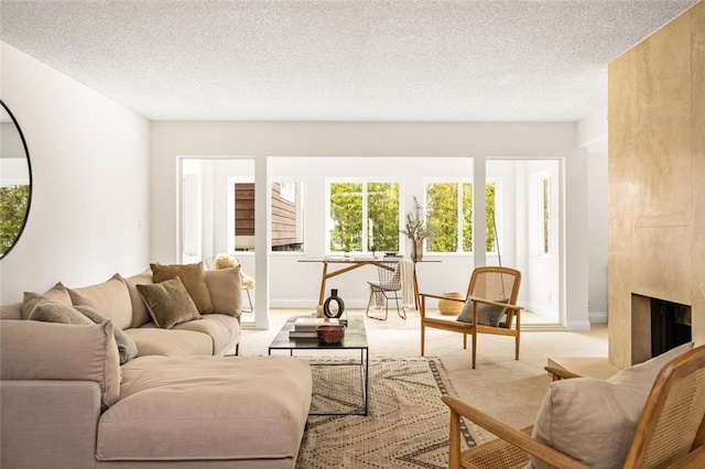4050 Via Dolce Unit 241, Marina Del Rey, CA 90292 - living area featuring light carpet, a textured ceiling, baseboards, and a high end fireplace