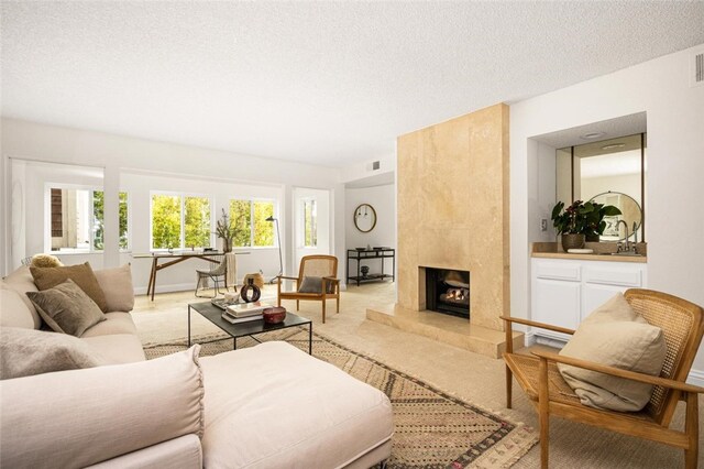4050 Via Dolce Unit 241, Marina Del Rey, CA 90292 - living room featuring a textured ceiling, light colored carpet, and a premium fireplace
