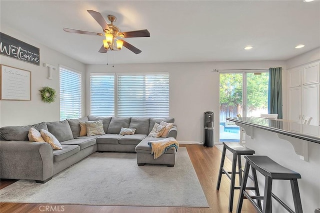 living area with light wood finished floors, ceiling fan, recessed lighting, and baseboards
