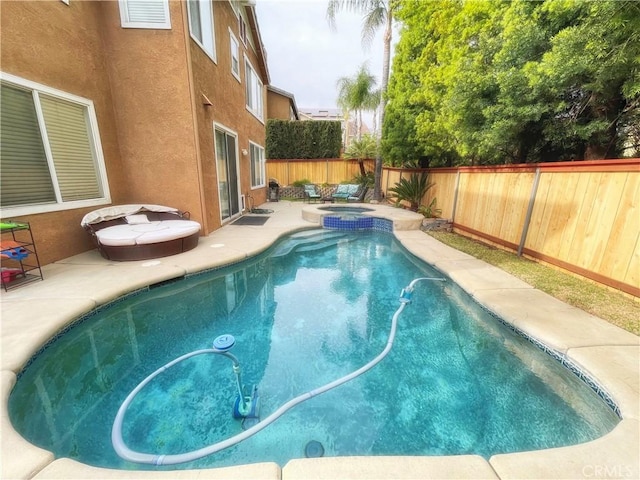 view of pool featuring a patio area, a fenced backyard, and a pool with connected hot tub