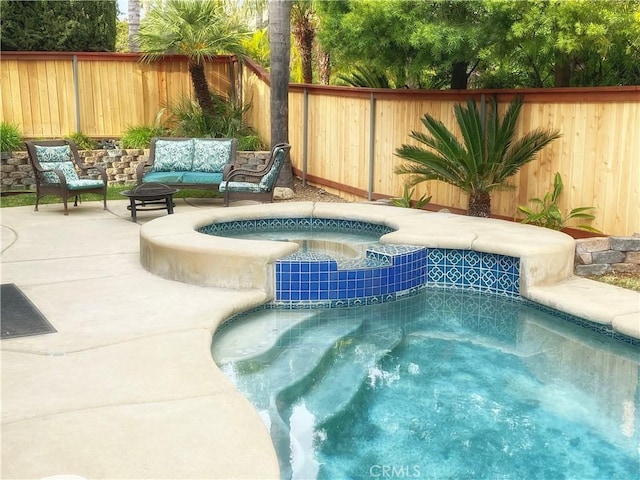 view of swimming pool with a pool with connected hot tub, a fenced backyard, a patio, and outdoor lounge area