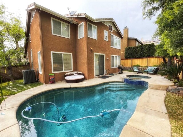 view of pool featuring a fenced backyard, a patio, a pool with connected hot tub, and cooling unit