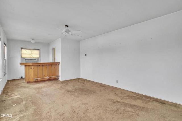 carpeted empty room featuring a ceiling fan and cooling unit