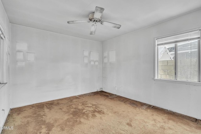 carpeted empty room featuring a ceiling fan