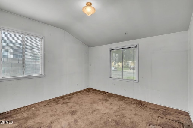 carpeted empty room with lofted ceiling