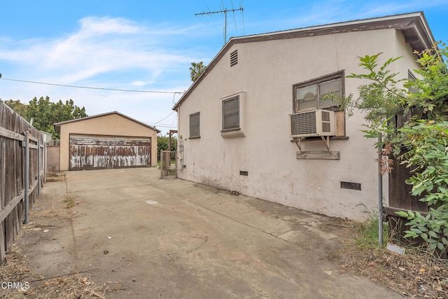 view of side of home featuring stucco siding, an outbuilding, and cooling unit