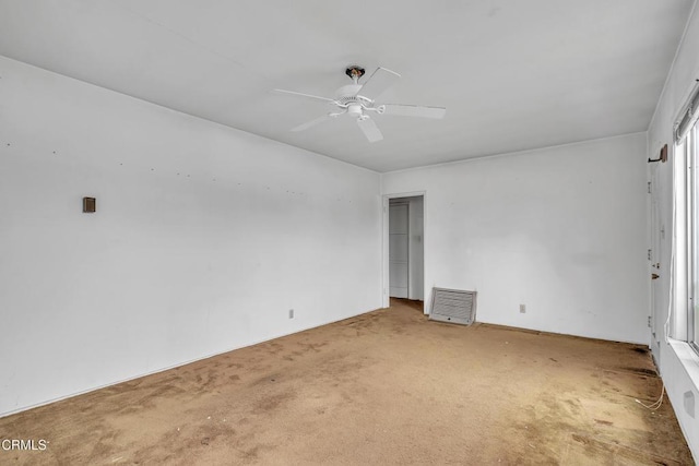 spare room with a ceiling fan and carpet