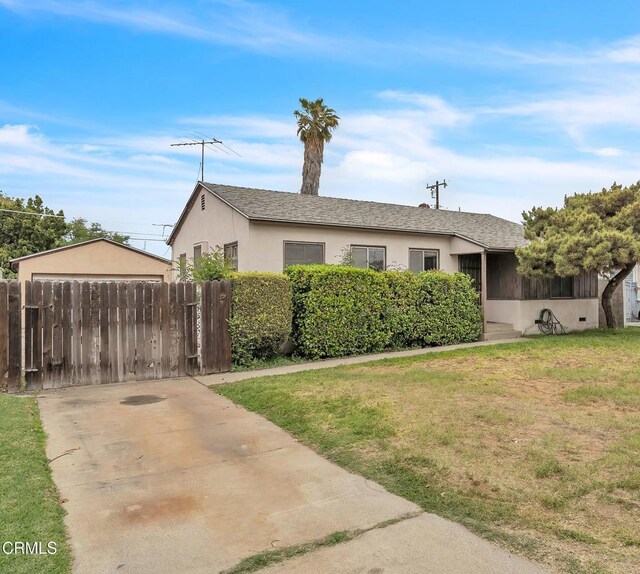 view of front of house featuring fence, a front lawn, and stucco siding